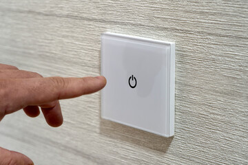 save energy concept,closeup of finger touching to electric switch. man's finger presses a...