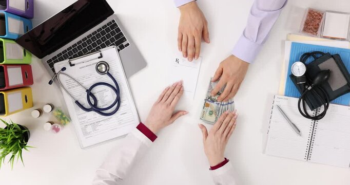 Doctor and patient exchange money for prescription in clinic