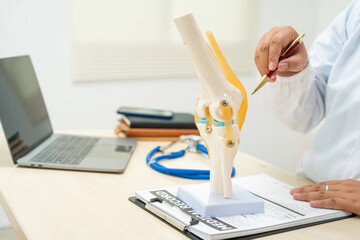 A female doctor works at a desk in the hospital, discussing bone and joint diseases like...