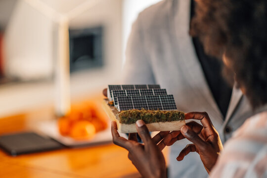 Close up of diverse businesswoman's hands holding solar panels model