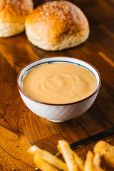 creamy orange color mayonnaise on a wooden table, rustic