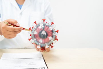 A female doctor sits at a table in a hospital, discussing the COVID-19 virus.She explains the...