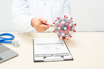 A female doctor sits at a table in a hospital, discussing the COVID-19 virus.She explains the...
