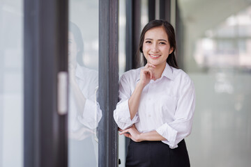 Happy confident asian professional business woman standing at work in office arms crossed looking away, asian businesswoman leader executive thinking of future success.