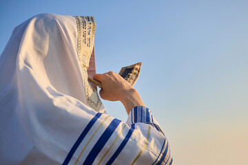 Jewish man blowing the Shofar rams horn on Rosh Hashanah and Yom Kippur day.