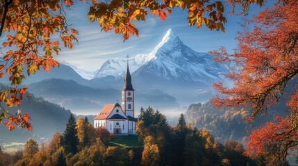 The iconic Maria Gern Church with snow-capped Hochkalter Peak at sunrise, framed by autumn foliage