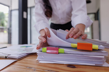 Obraz premium Business colleagues reviewing financial documents and calculating taxes. Auditor inspecting financial reports with magnifying glass. Business audit, taxes and forensic accounting concept 
