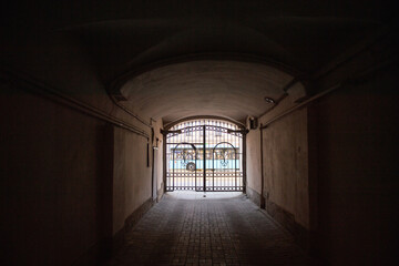 A long dark arch with a metal fence