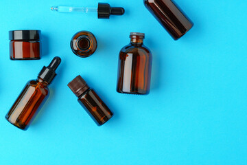 Collection of Amber Glass Bottles and Jars Displayed on Bright Blue Background