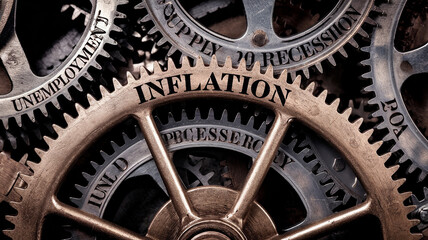 Close-up of interconnected copper gears with words 'INFLATION' and 'RECESSION', symbolizing economic concepts of inflation and recession.