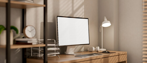 A contemporary minimalist home office workspace features a computer on a wooden desk.