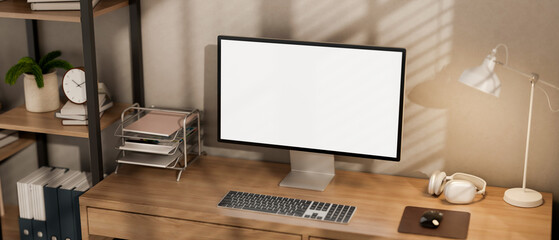A minimalist computer desk featuring a computer and decor on the wooden desk in a room.