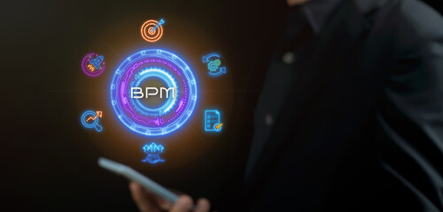 BPM, Business process management concept. Business data analytics and business strategic planning. Businessman using smartphone with glowing neon line of BPM icons on virtual screen.
