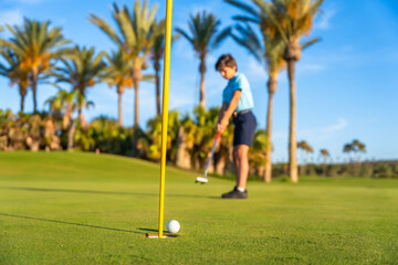 A young male golfer making a put