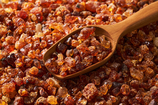 closeup acacia gum or gam arabic in wood scoop background