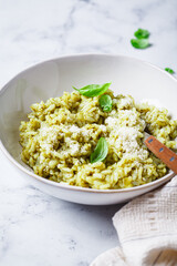 Green pesto risotto with parmesan, white background.