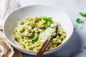Green pesto risotto with parmesan, white background.