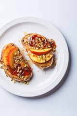 Peanut butter and jam jam with peach and nuts, white background.