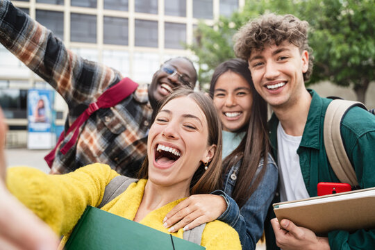 Happy university student friends taking a selfie photo in the campus, celebrating academic course on social media