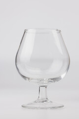 Elegant vertical photo of an empty wine glass centered against a minimalist white background