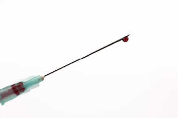 Fototapeta premium Close-Up of Syringe Needle with Blood Drop Centered