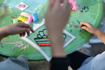 Mother and daughter doing colorful crafts in outdoor garden
