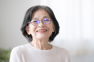 Fototapeta premium 笑顔のシニア女性 部屋の中で大笑いする健康的な高齢者女性のクローズアップ カメラ目線