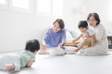 Image of a Japanese child (grandchild), mother, grandmother and crawling baby Close family happiness