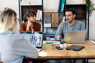 Businessman discussing strategies with colleagues sitting at office