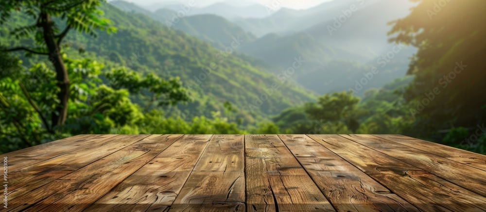 Poster wooden table with a mountain and green nature blur in the background offering a copy space image on 