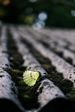 Yellow shuttlecock on corrugated rooftop