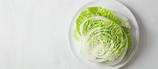 Obraz premium Top view of sliced fresh cabbage on white plate isolated on a white background with copy space image showcasing the benefits of this healthy vegetable in a flat lay composition