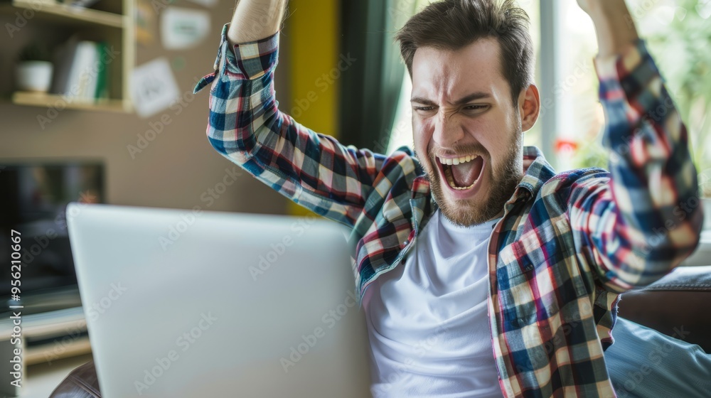 Poster a man is sitting on a couch with a laptop in front of him
