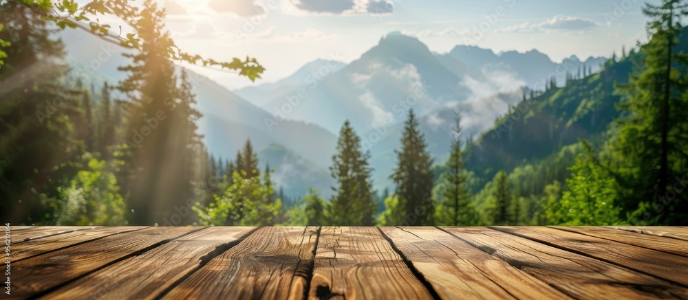 Poster wooden table with a mountain and green nature blur in the background offering a copy space image on 