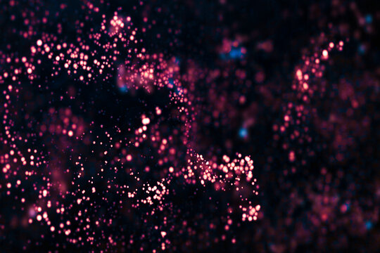 Abstract illustration of glittering particles in dark background