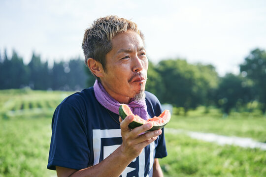 収穫した小玉スイカの味見をする日本の農家さん