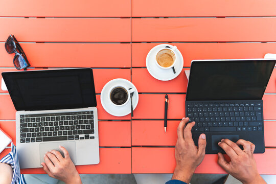 Hands of business colleagues using laptop outside cafeteria