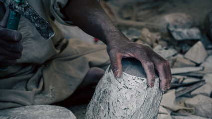 hands of a male Egyptian sculptor while working with a stone alabaster