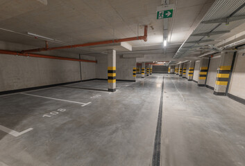 Empty underground multi-storey car park without cars, empty parking spaces