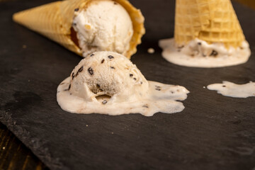 creamy ice cream with pieces of chocolate on a black slate