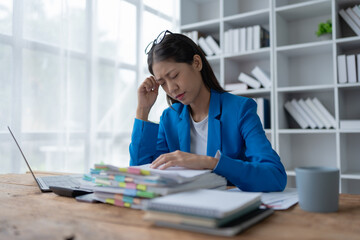 businesswoman plans a finance audit, reviewing documents while battling burnout syndrome.