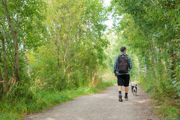 A man walks in the park with a Black and tan Japanese Shiba Inu breed, a friendship of human and dog, pet walking with the owner in the park in Finland, Europe