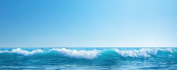 Fototapeta premium A serene ocean view with gentle waves under a clear blue sky, perfect for conveying tranquility and nature's beauty.