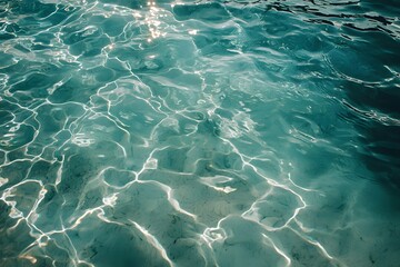 Clear turquoise water reflecting sunlight in a serene setting.