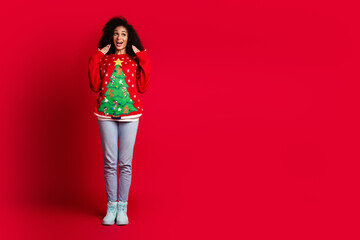 Photo of charming attractive glad girl wear stylish ugly print sweater look empty space isolated on red color background