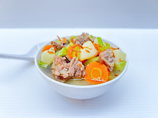 Beef soup, with carrots, potatoes and tomatoes.