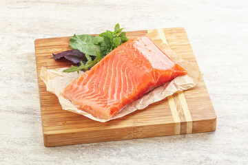 Raw salmon fillet over board