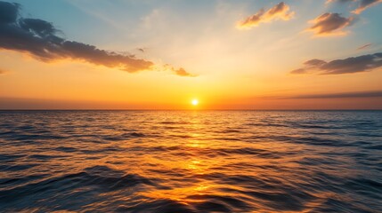 Fototapeta premium The sun is setting over the ocean, casting a warm glow on the water