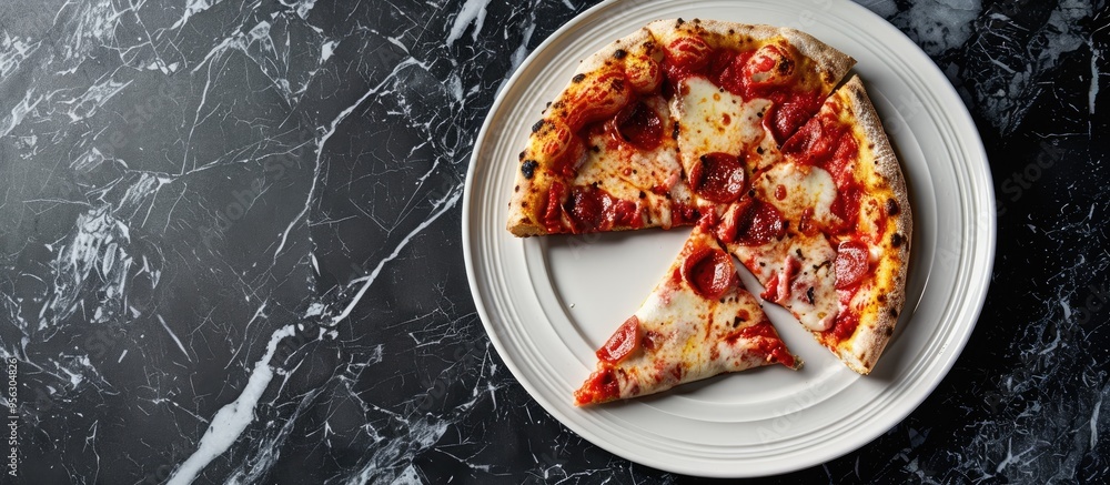 Poster pizza slice being bitten on a white plate against a black marble backdrop with copy space image