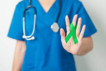 Doctor with green Ribbon for world Lymphoma Awareness September month, world Mental Health Day, Liver, Gallbladders, bile duct, cervical, kidney Cancer. Healthcare and world cancer day concept